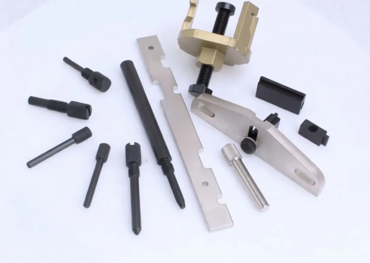 Angled view of engine locking tools: brass clamp, notched silver plate, two-hole bracket, knurled pins and black alignment shaft, some marked ASTA