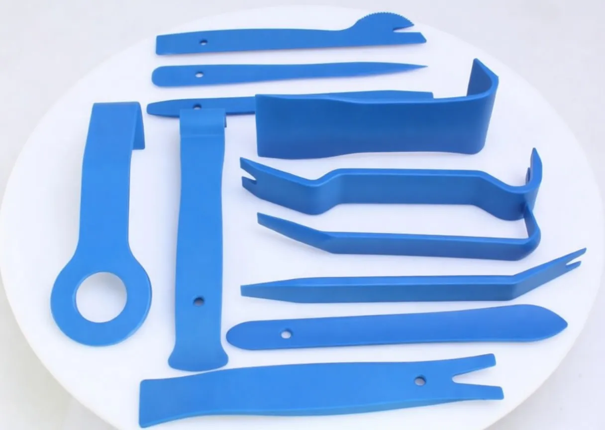 Twelve blue plastic trim removal tools of various shapes and sizes on a white background