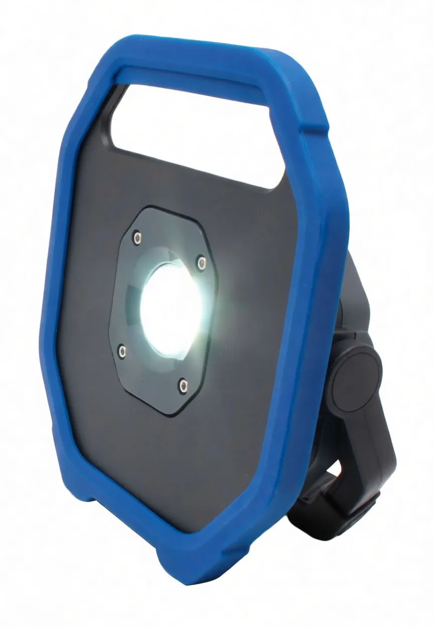 Angled view of ASTA flood lamp switched on with bright central COB LED and carrying handle visible