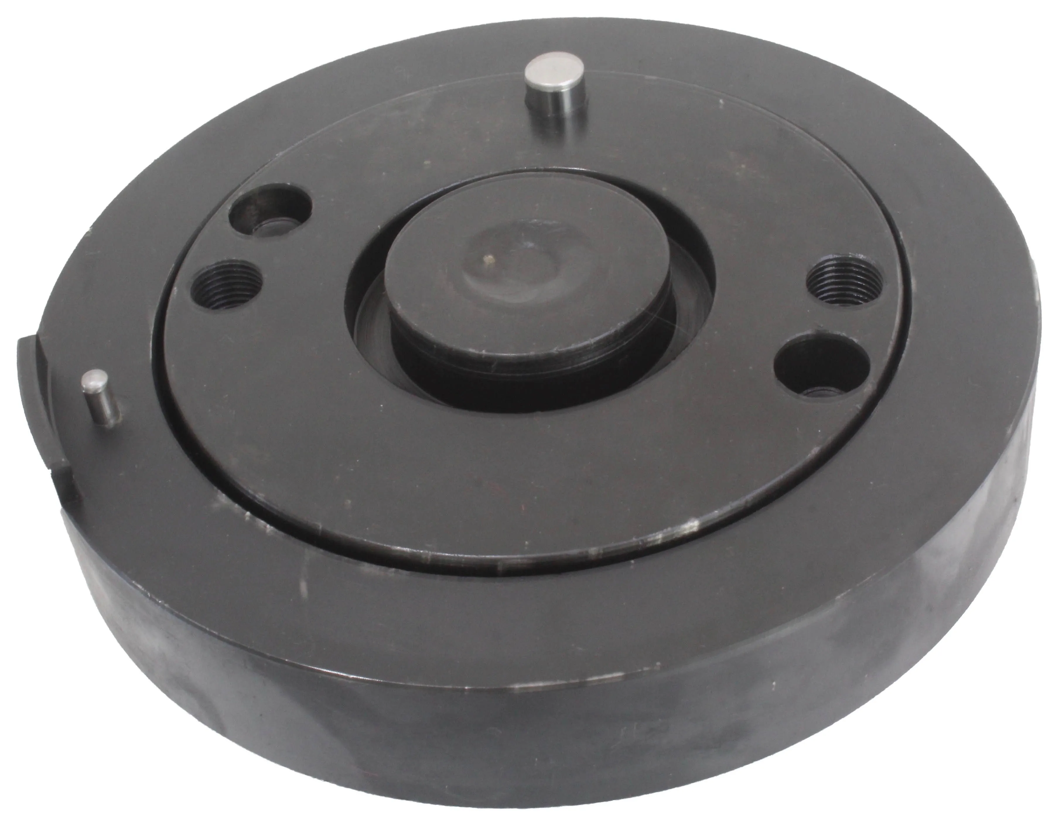 Angled top view of black round crank trigger wheel installer showing central boss, threaded holes and locating pins