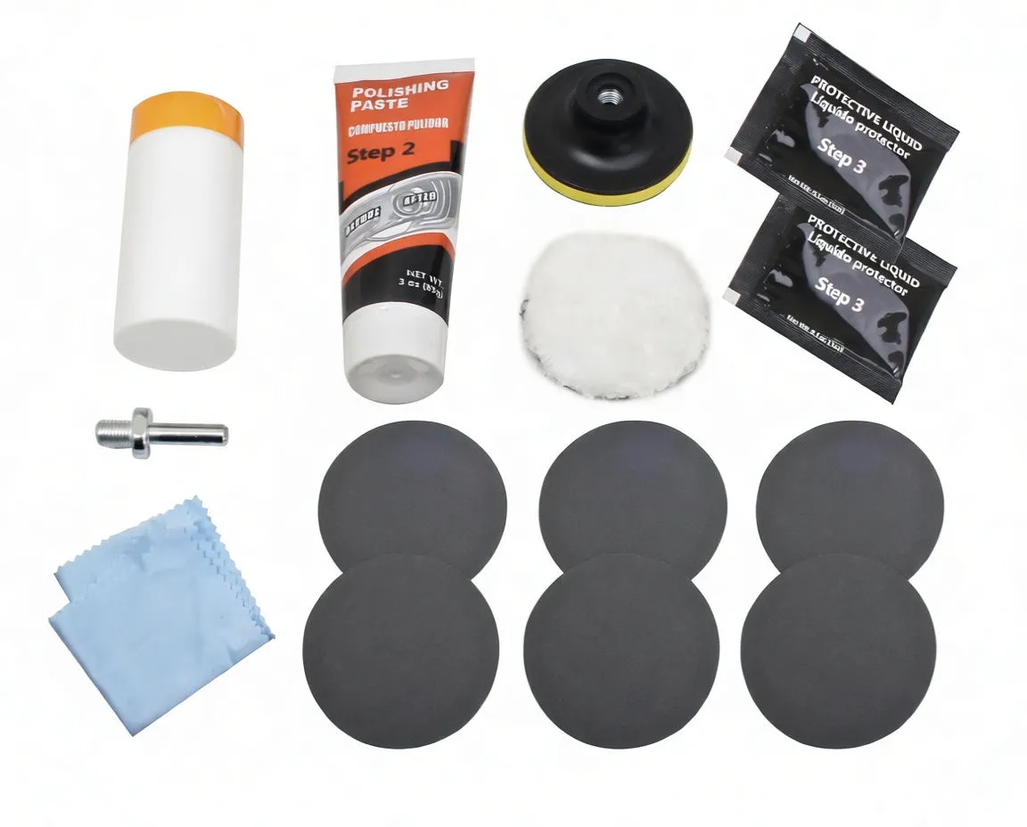 Flat lay of headlight restoration kit pieces: paste tube, compound bottle, protective sachets, buffing pad, sanding discs and adapter