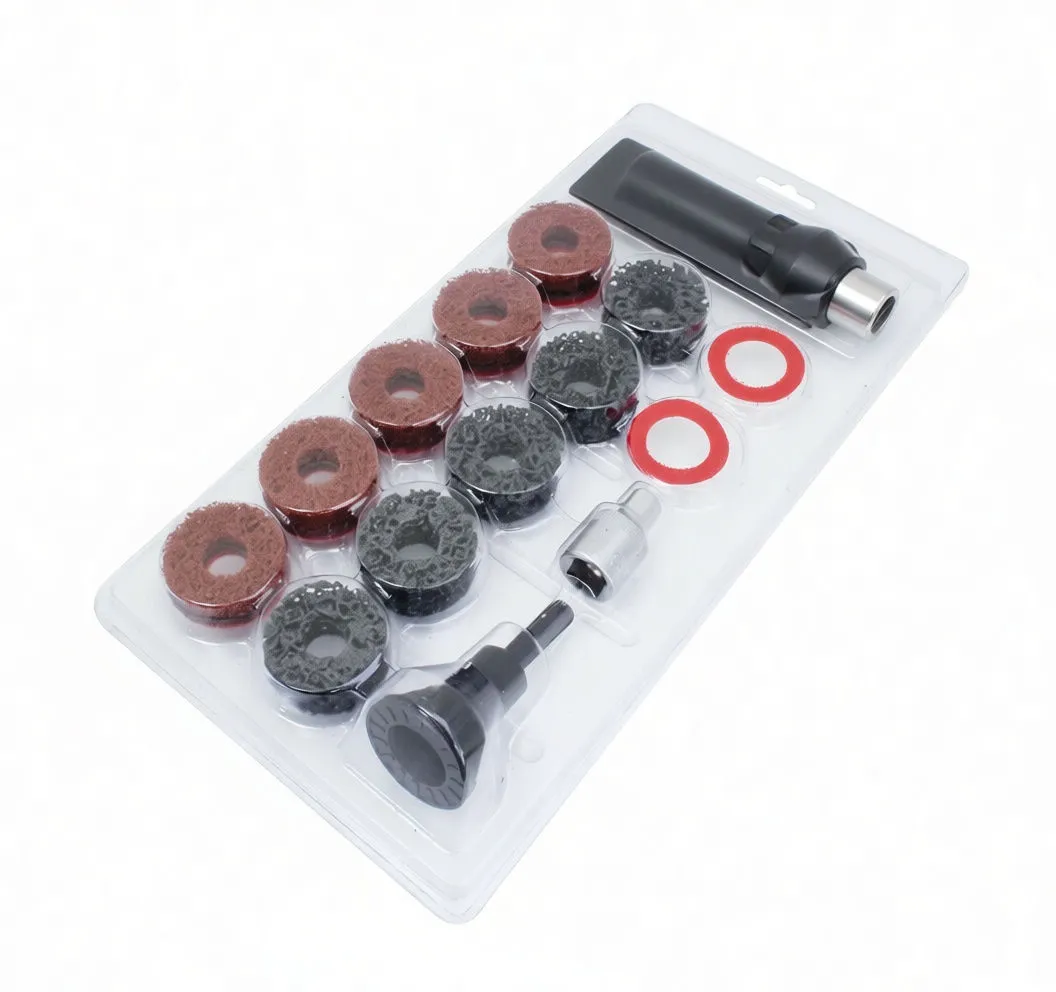 Top view of many donut abrasive pads with two red rings and two adapters (black mandrel and silver socket) arranged on white surface