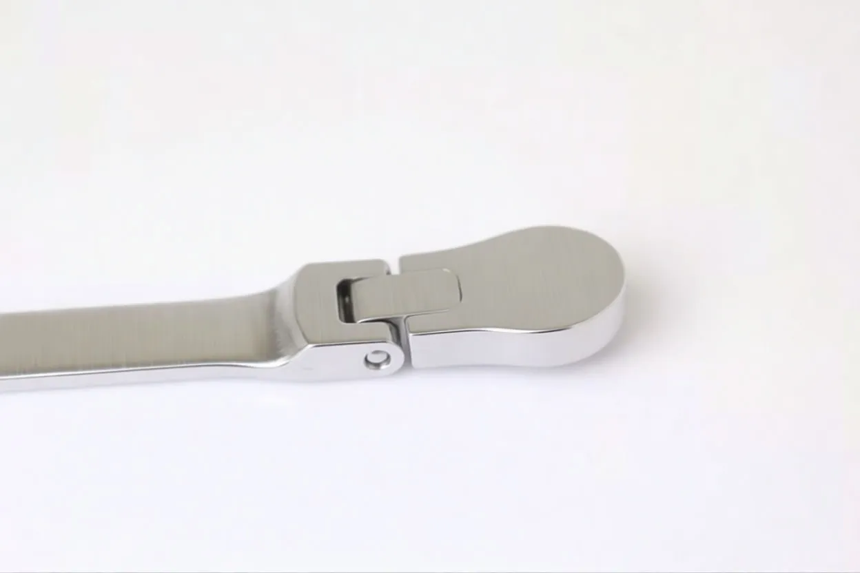 Close-up of the spanner's ratchet head showing pivot joint, black ratchet gear cover and part of the chrome handle with a faint stamped mark.