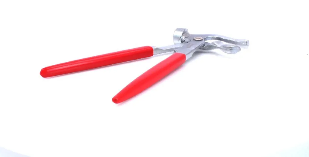 Low-angle view of red-handled wheel-weight pliers showing handles, pivot and hooked jaws