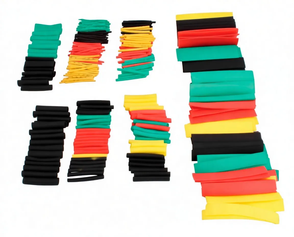 Assorted heat shrink tubing sorted into piles on a white surface, showing different diameters and colors.