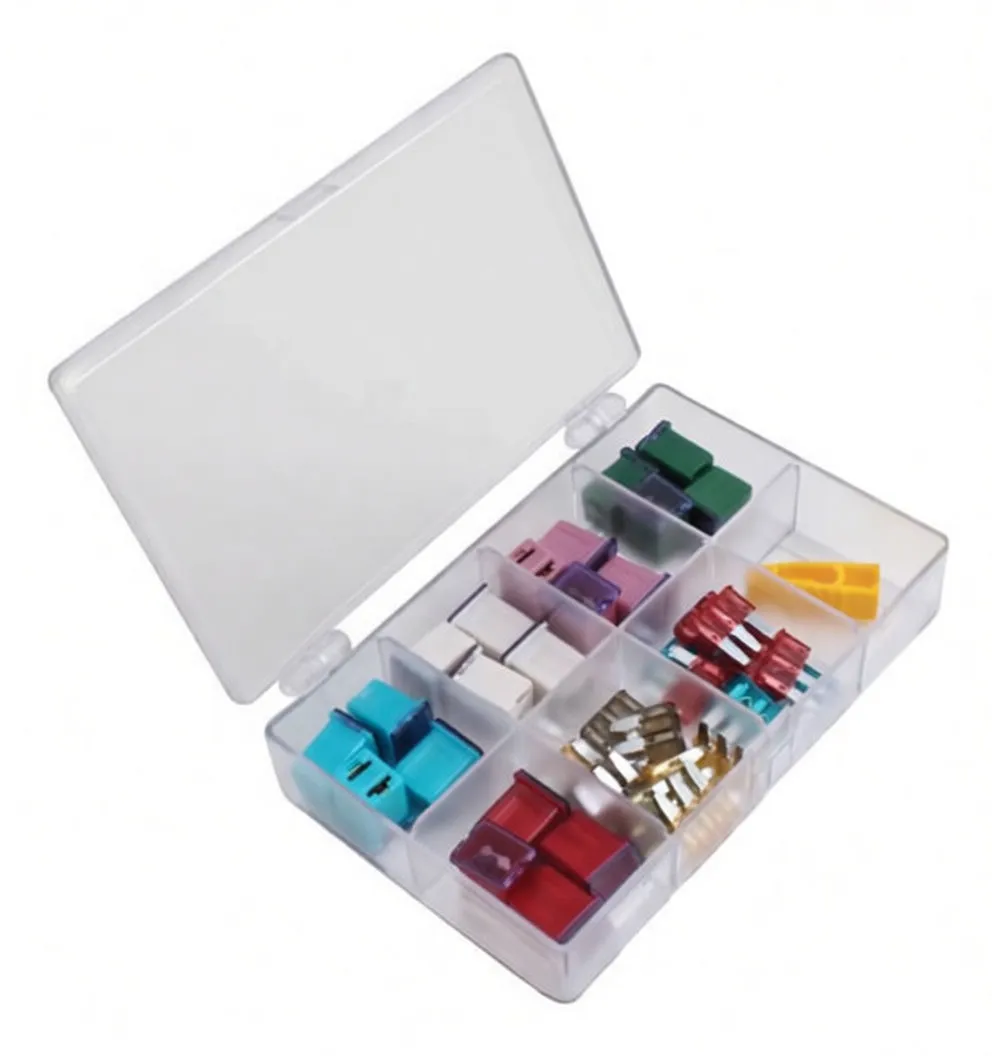 Angled photo of a clear plastic fuse kit box with colored blade fuses, metal terminals and a yellow puller; inside lid displays a printed fuse/amperage guide.