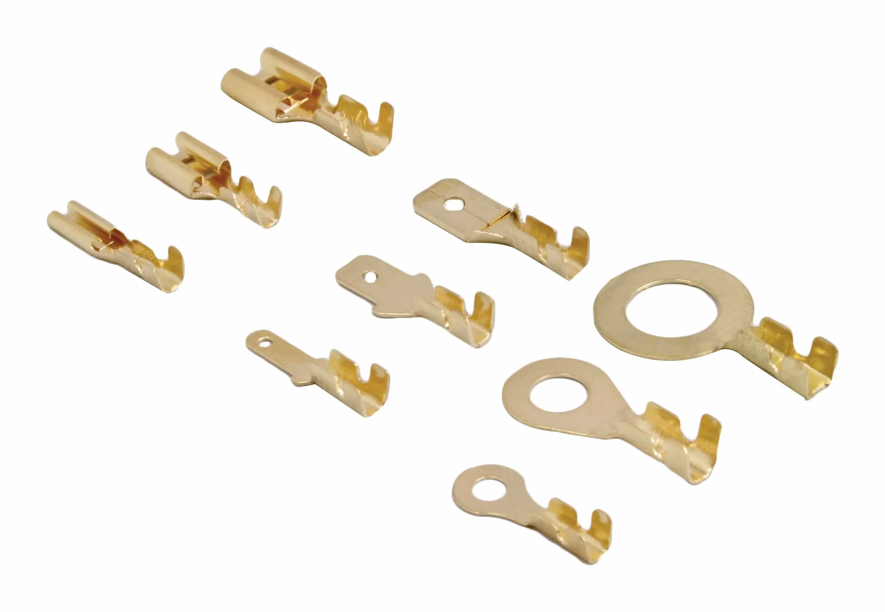 Close-up of assorted gold-colored non-insulated crimp terminals and ring connectors laid out on white background