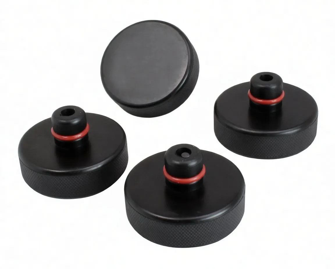 Four black rubber jack pads, three showing posts with red rings and one showing flat face