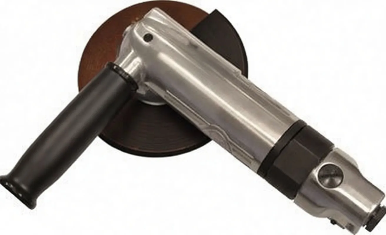 Overhead angled view of angle grinder showing metal body, black handle, disc and red safety sticker on the head