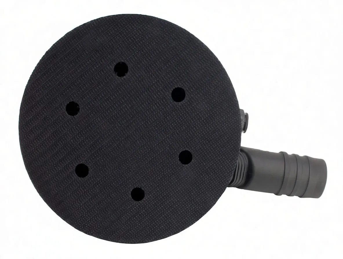 Bottom view of round sanding pad showing six dust extraction holes, textured hook-and-loop surface and hose adapter