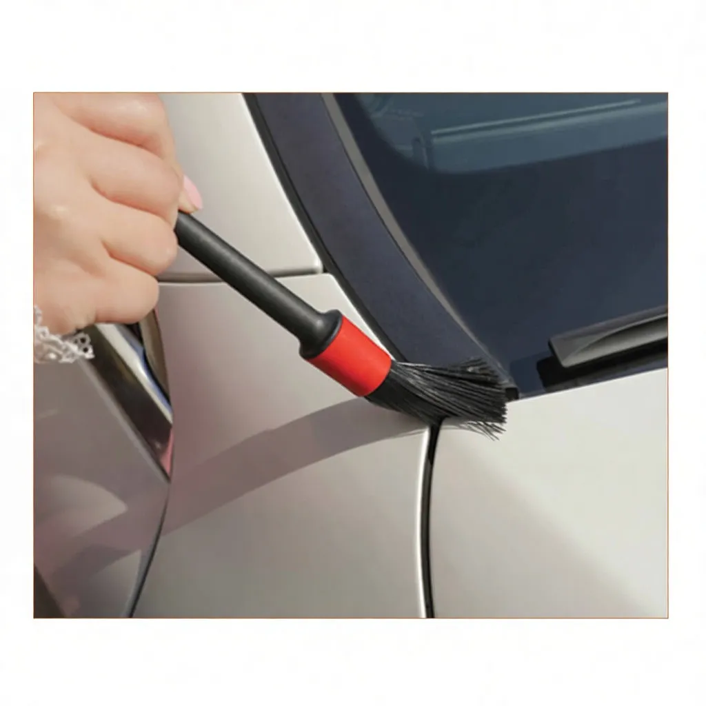 Detailing brush cleaning seam near windshield, showing red-accent bristles and Hyundai text in background