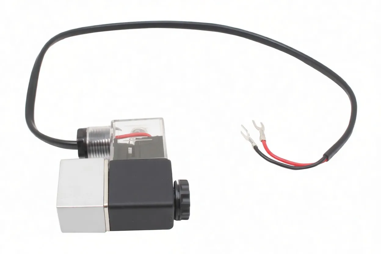 Side view of solenoid valve; black labeled coil, transparent terminal box, silver ported valve body and cable with fork terminals visible.
