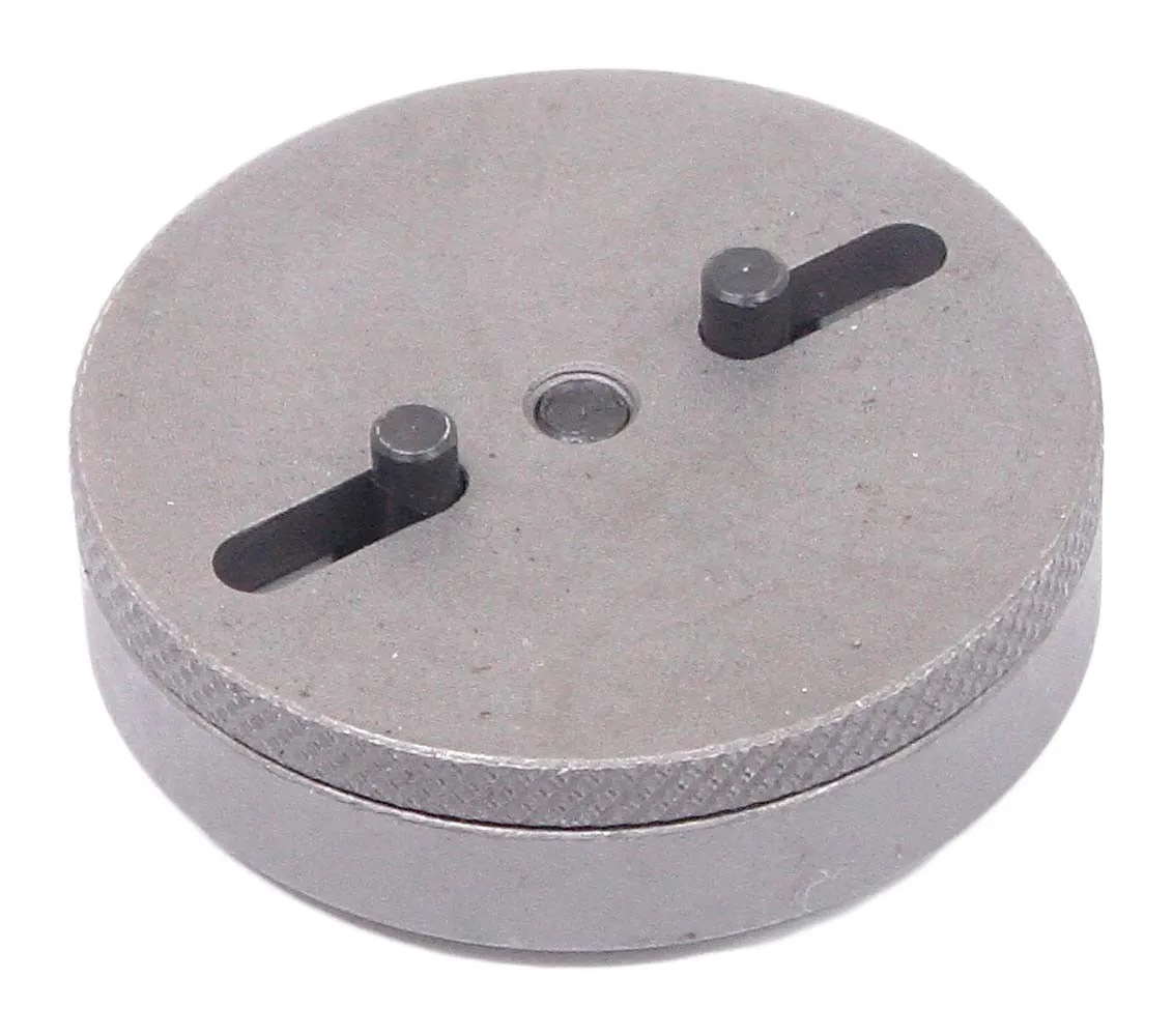 Back side of round brake caliper adapter showing two adjustable cylindrical pins in slots, central hole and knurled edge