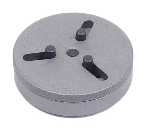 Bottom view of round adapter showing three pins in radial slots and knurled edge