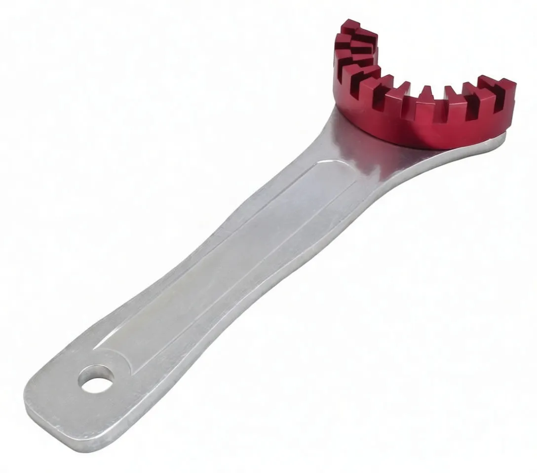 Three-quarter view of entire silver wrench with red semicircular toothed ring and brand marking on handle