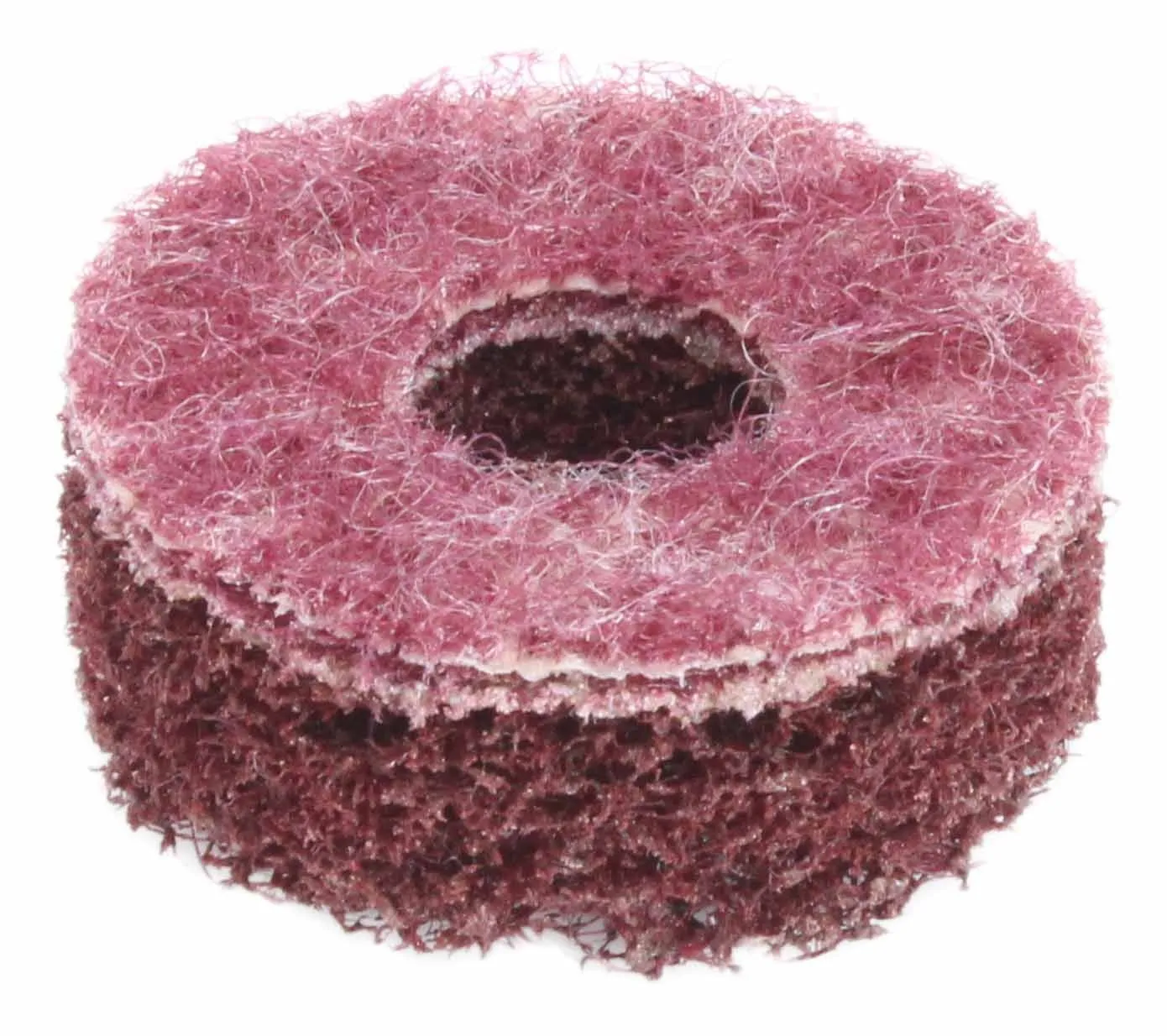 Angled view of stacked maroon/pink coarse sanding discs with central hole and visible fibrous layers