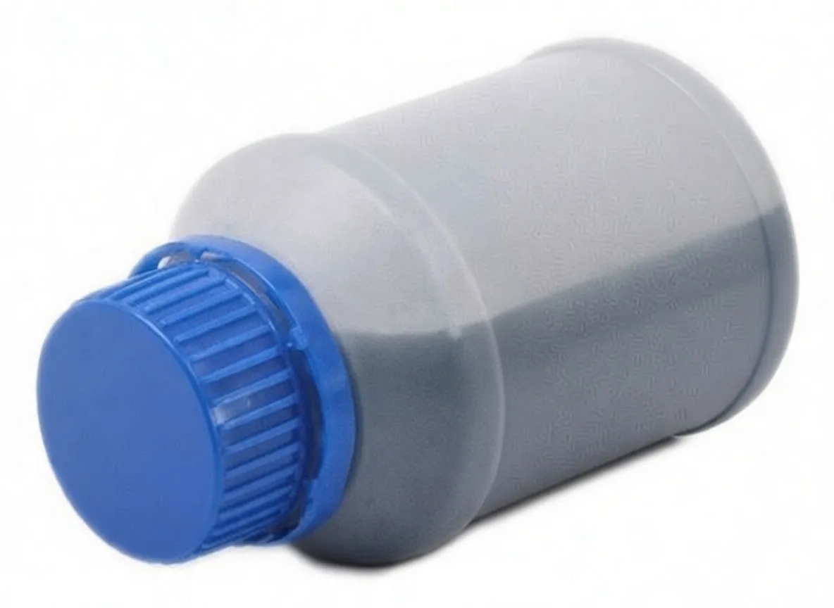 Bottle on its side showing blue screw cap, translucent body with dark liquid and ASTA label with barcode.