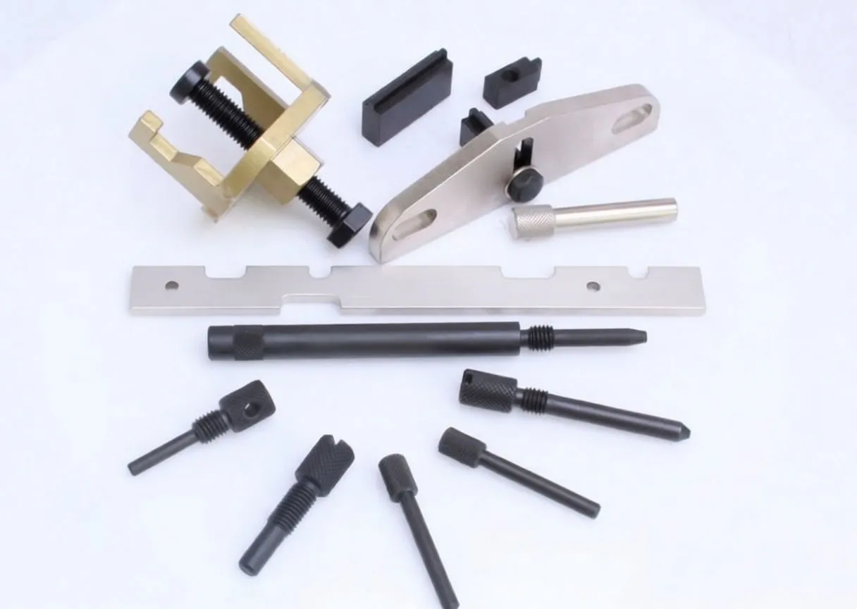 Close-up flat layout of engine timing/locking tools: brass clamp, silver plates, black alignment rod and multiple black pins, some marked ASTA
