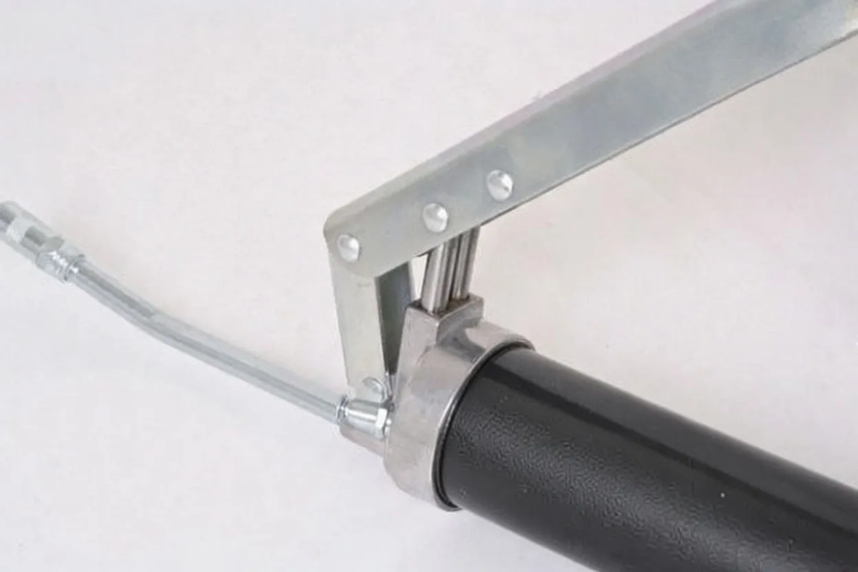 Close-up of grease gun hinge, dual piston rods, barrel marking and nozzle coupling