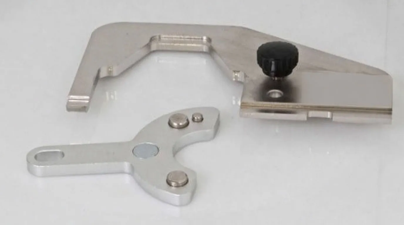 Alternate view of U-shaped fork, clamping plate with black knob and three-pronged adaptor, showing machined locating features.