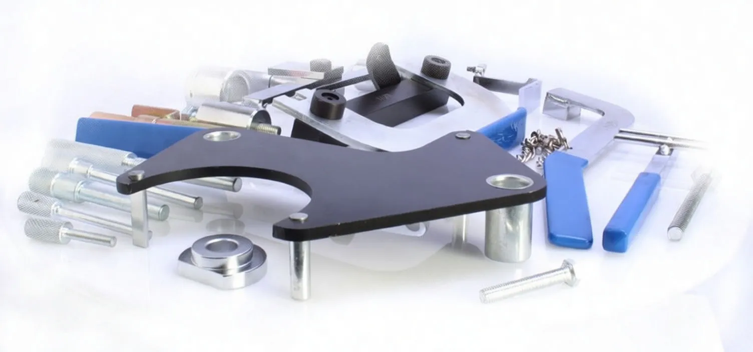 Close-up view of black locking plate, alignment pins, spacers, chain and blue-handled tools from a vehicle engine locking set