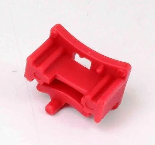Red plastic locator/clip from engine locking kit, curved with slots and small protruding pins