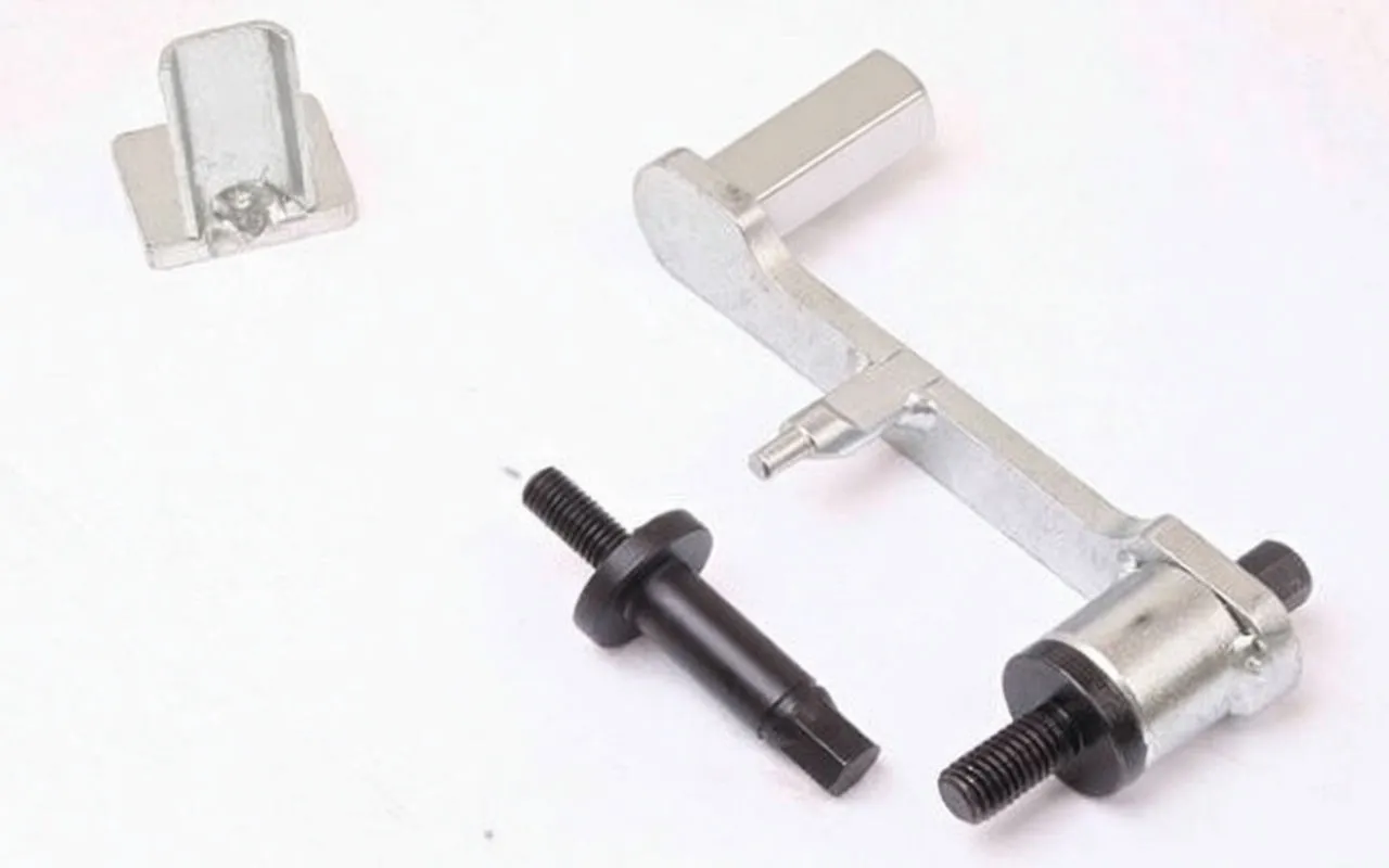 Close-up of L-shaped alignment bracket, black threaded pin and small adapter, some parts stamped 'satra'