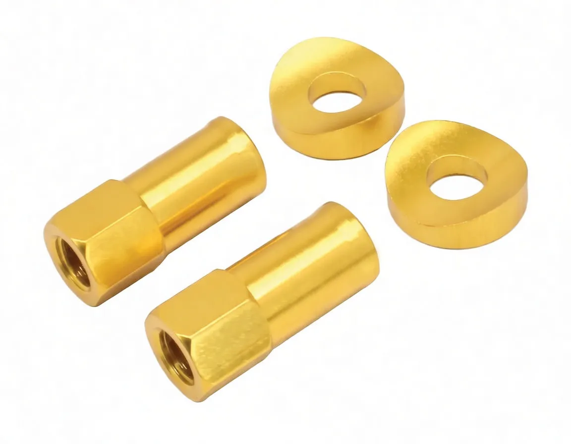 Diagonal arrangement of two metallic gold extended lock nuts (one with white ASVA logo) and two gold beveled spacers with central holes and sloped faces.