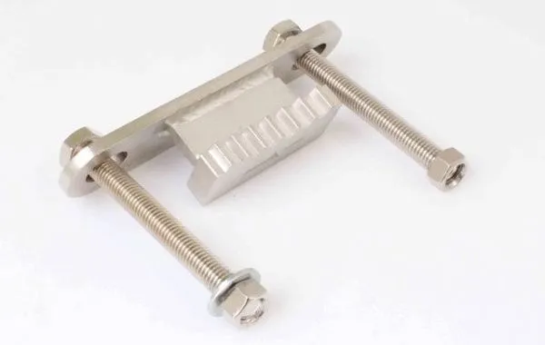 Side view of metal flywheel stopper showing toothed block, weld bead, mounting plate and threaded bolts