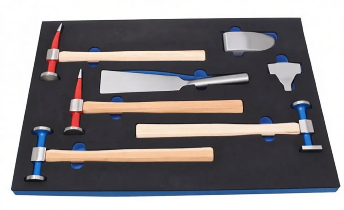 Foam drawer insert with wooden-handled hammers, spoon dolly and semicircular steel dollies, ASTA logo on foam