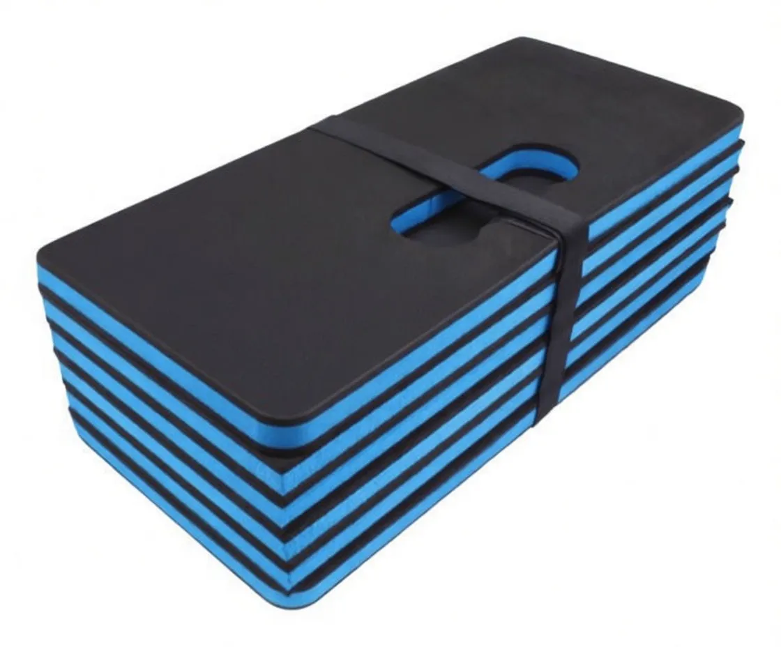 top view of folded black and blue folding work mat with label, strap and printed brand text