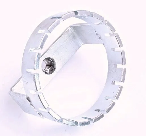angled view of ring-style fuel tank lid wrench showing slots and recessed drive in bridge