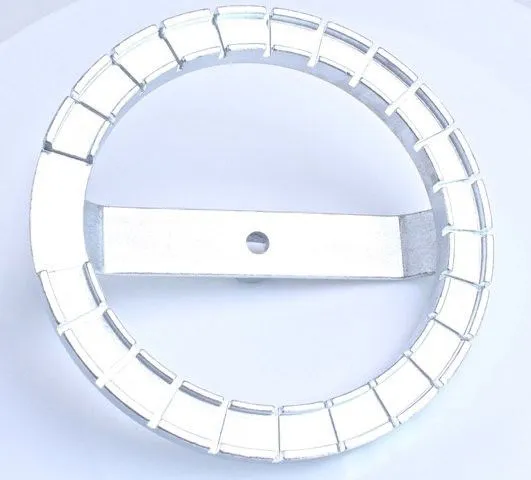 top view of a metal notched circular ring tool with segmented inner tabs and a central crossbar with a hole for a drive connection