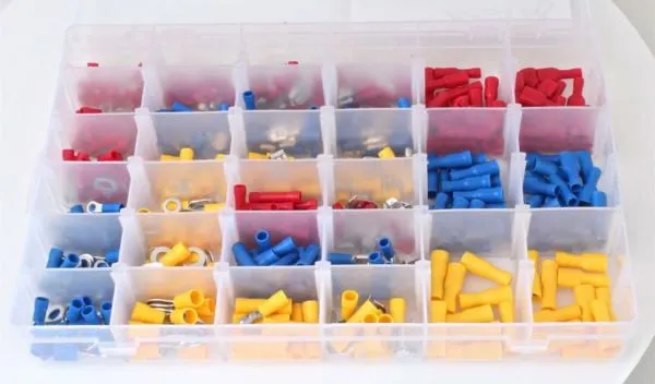 Close top view of compartmented box filled with red, blue and yellow insulated cable lugs and crimp terminals