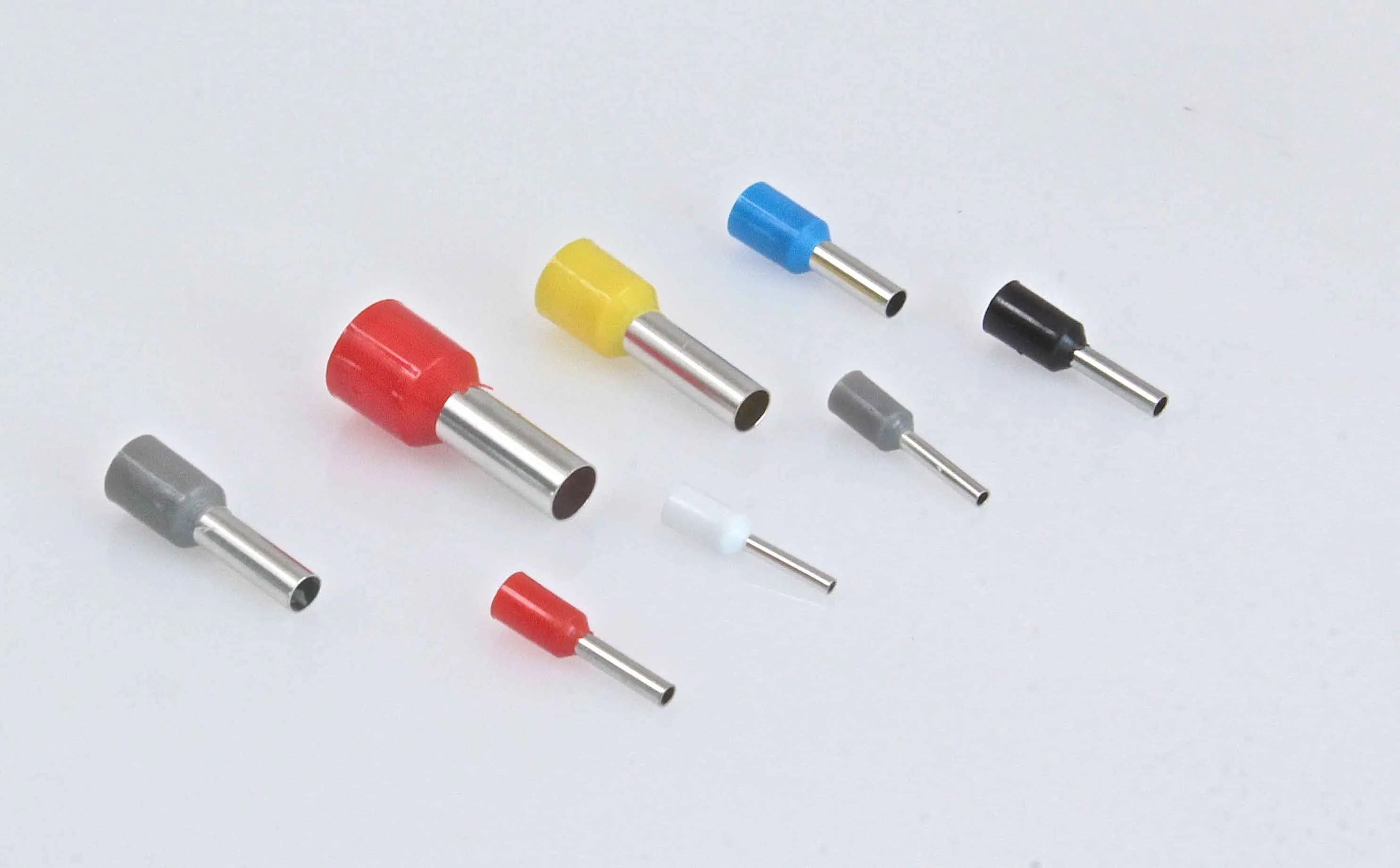 Close-up of various insulated cord end terminals showing metal barrels with colored insulating collars in multiple sizes and colors.