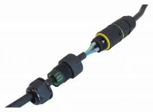 Cable connector in use with cables inserted, green internal insert and tightened cable gland showing conductors and sealing