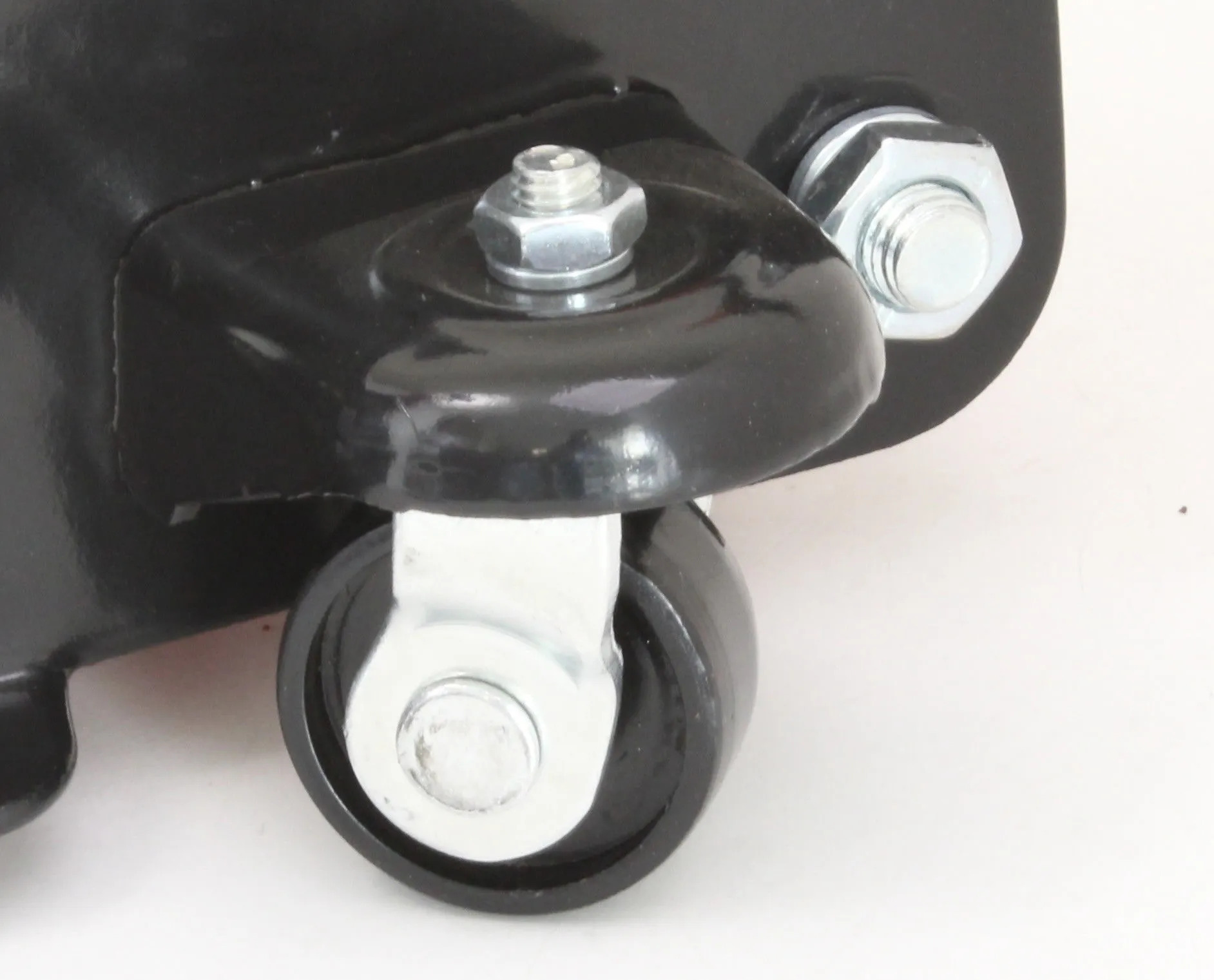 Close-up of a small swivel caster wheel and metal mounting bracket on a floor jack