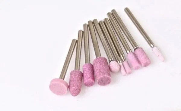 Set of pink abrasive grinding stones on metal shanks in various shapes and sizes