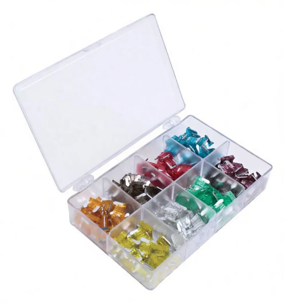 Angled shot of transparent hinged case with amperage-color chart in lid and assorted colored micro blade fuses in separated compartments, showing metal blades and plastic bodies.