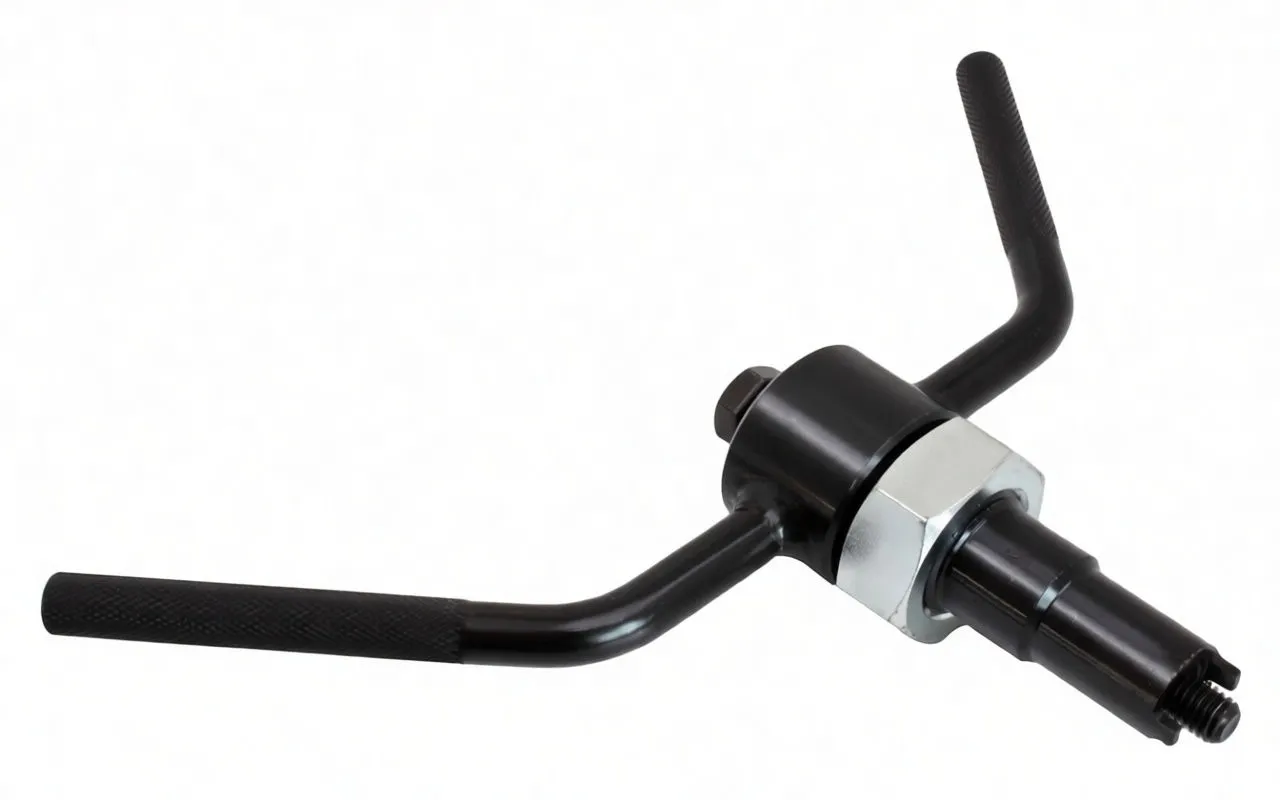 Angled view of black crankshaft turning tool with textured handles, central hub, silver hex nut and ASTA A-MK384 marking.