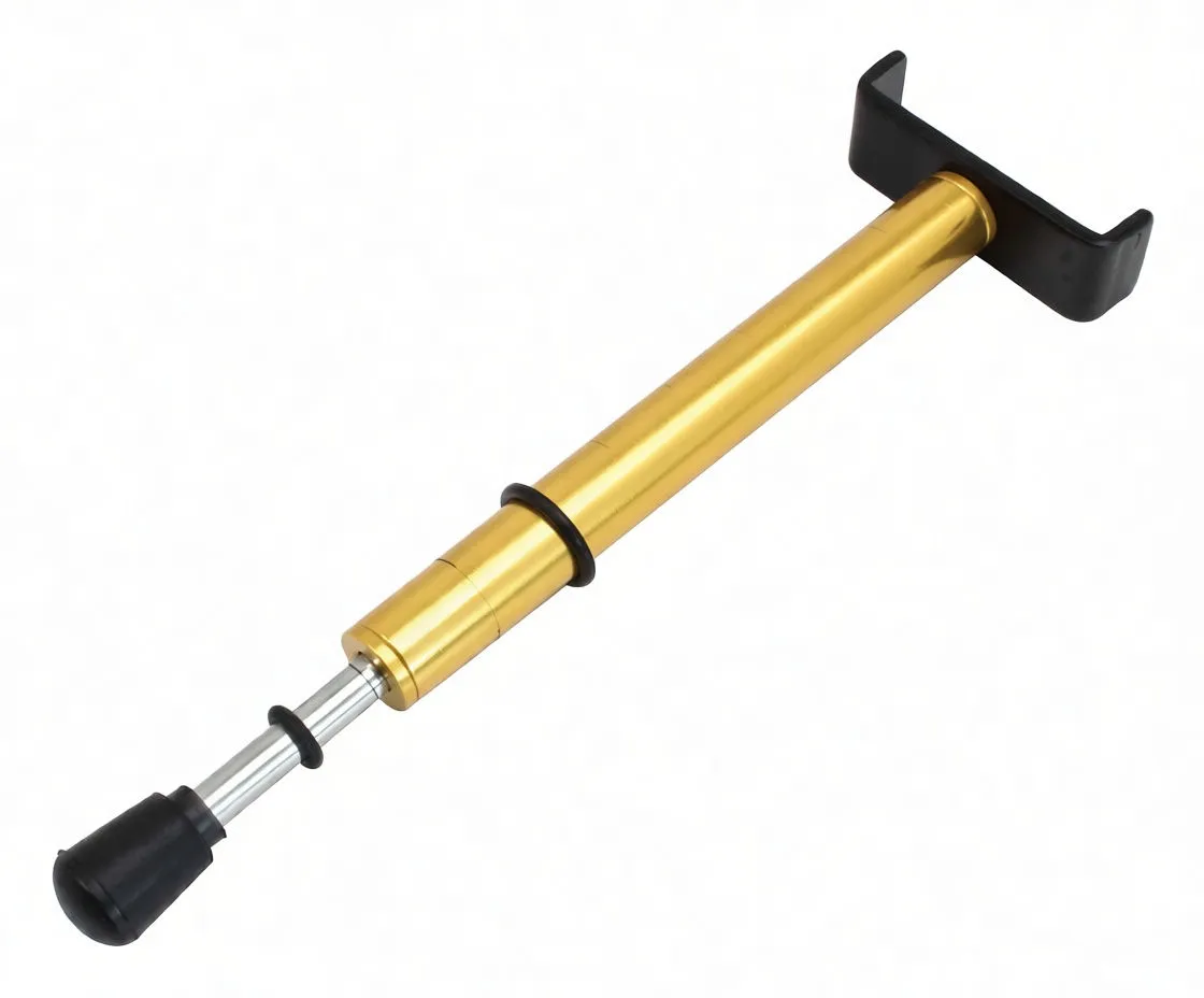 Oblique view of belt tension gauge showing text 'BELT TENSION GAUGE', scale markings, black U-shaped bracket and rubber-tipped plunger