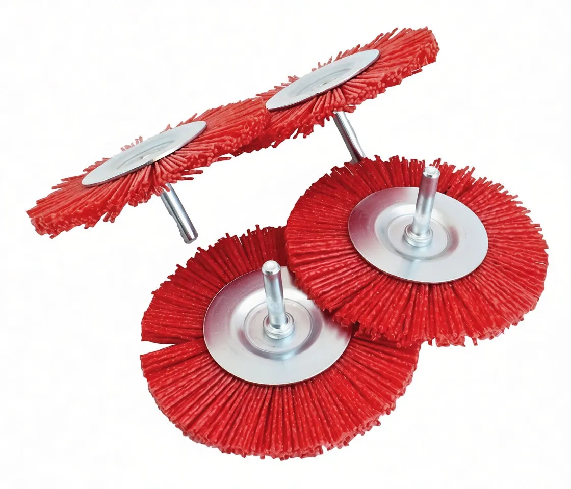 Angled shot of red nylon brush discs showing edge profile, metal backing plates and mounting shanks