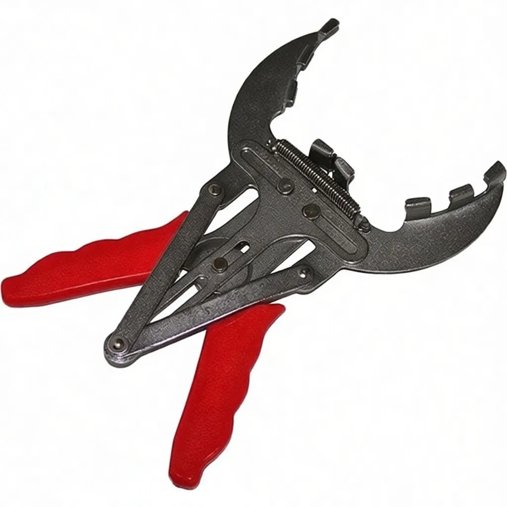 Close-up of metal piston ring expander with notched jaws and red handles