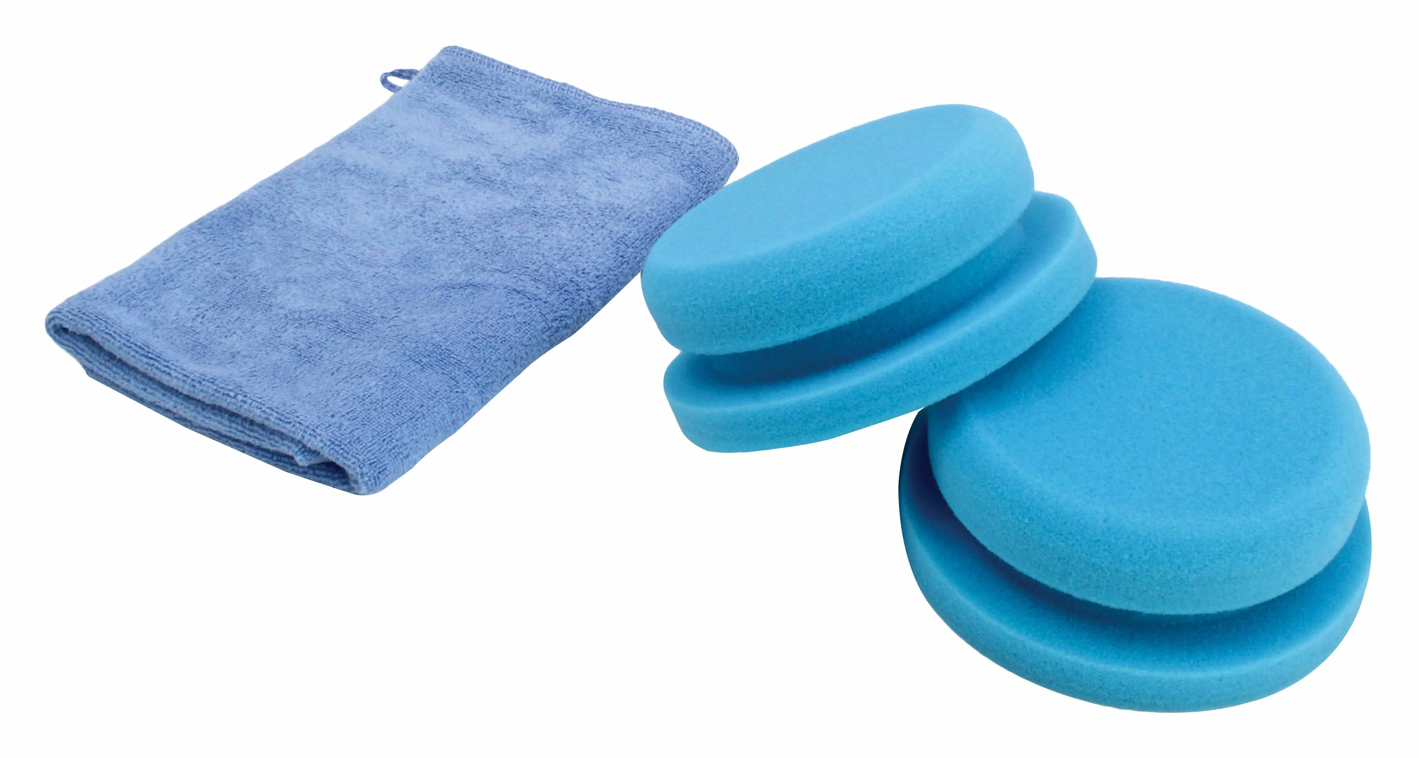 Angled shot of two blue round foam polishing sponges, one leaning on the other, with a folded light-blue microfiber cloth to the left on a white background.