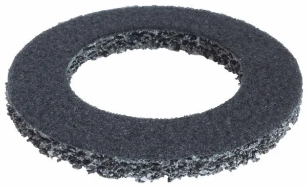Angled top and side view of a dark gray circular replacement grinding wheel with a smoother pad-like top surface and coarse open-web sides, showing center hole