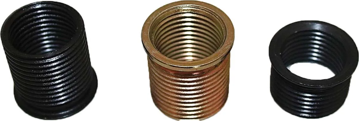 Three close-up threaded inserts: black, brass, and black, showing helical threads and small flanges used for spark plug thread repair.