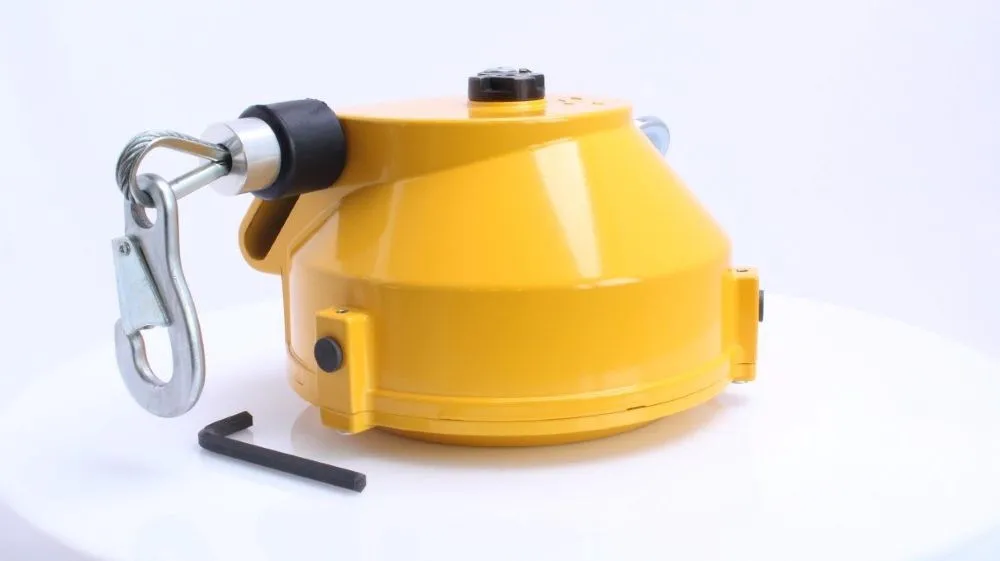 Angled side view of yellow spiral spring balancer with cable hook, top adjustment cap, side latches and Allen wrench