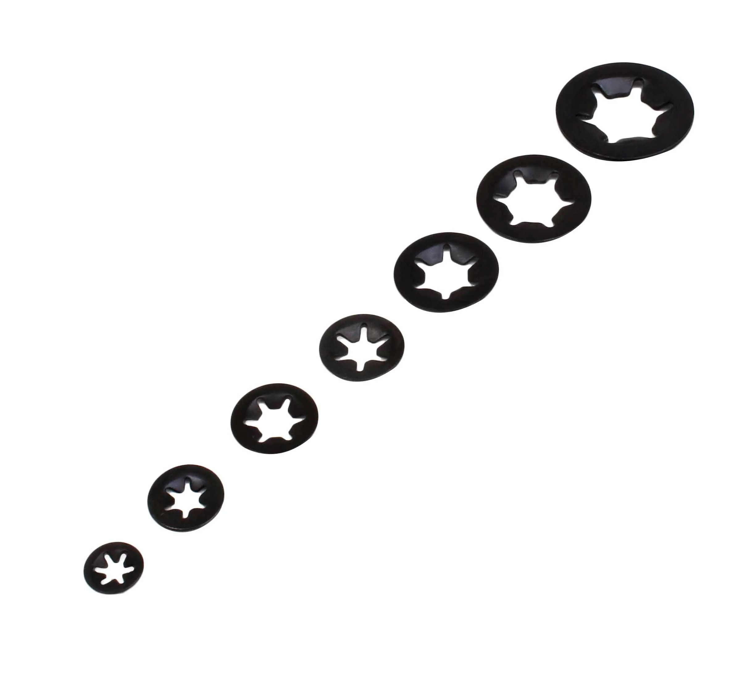 Seven black internal-star spring lock washers in a row on white background, showing increasing diameters and star-shaped inner teeth.