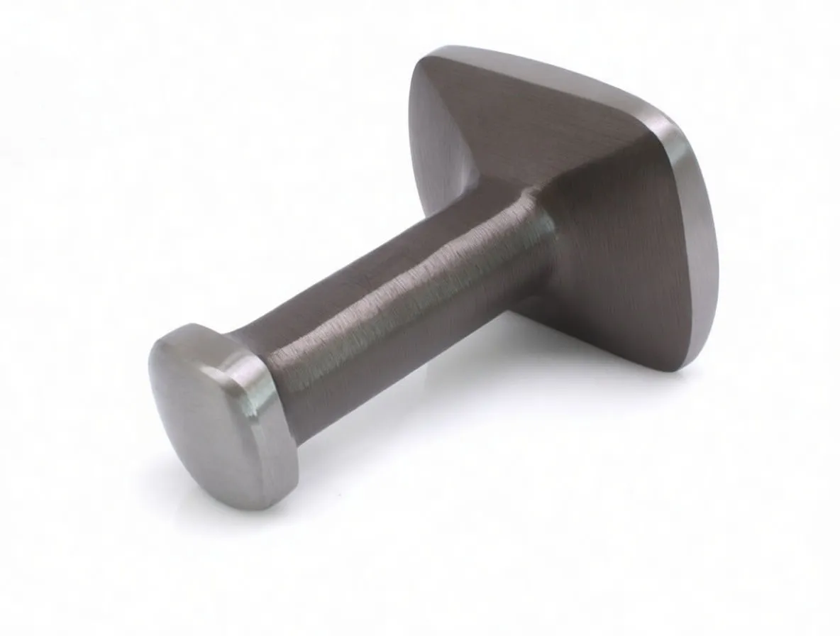 Back-side view of brushed-metal meat tenderiser showing tapered head-to-handle connection, round end cap and a partially readable barcode/warning label on the handle.