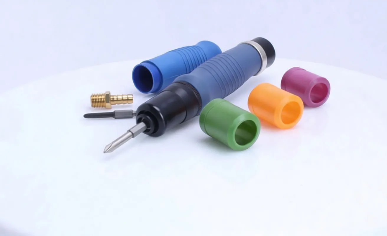 Blue pneumatic screwdriver with brass air fitting, spare bit and four colored plastic caps (green, orange, purple, blue) on white background.